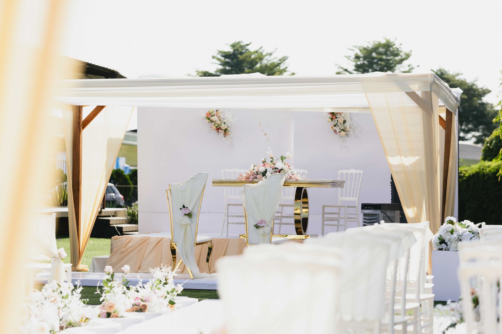 Romantic outdoor wedding venue decorated with flowers and soft draping